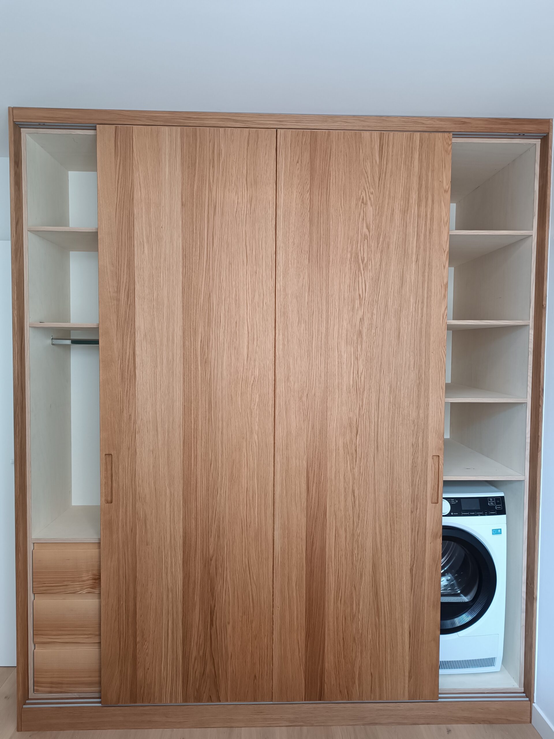 Custom-made oak veneer cabinet with sliding doors concealing utility area