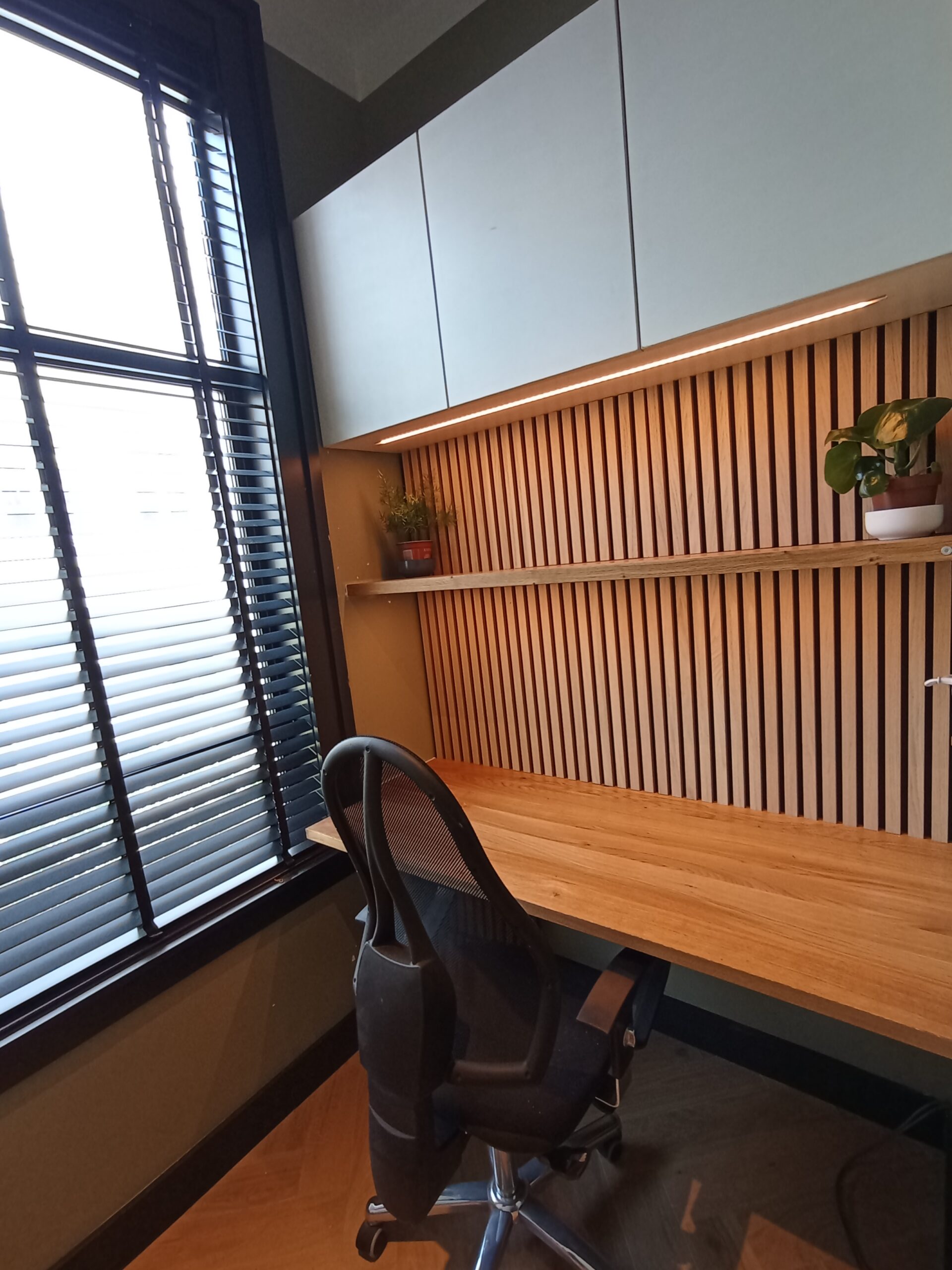 Integrated custom desk and slatted oak workstation, angled view